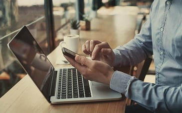 office-worker-practicing-email-content-filtering-best-practices-on-laptop-cell-phone