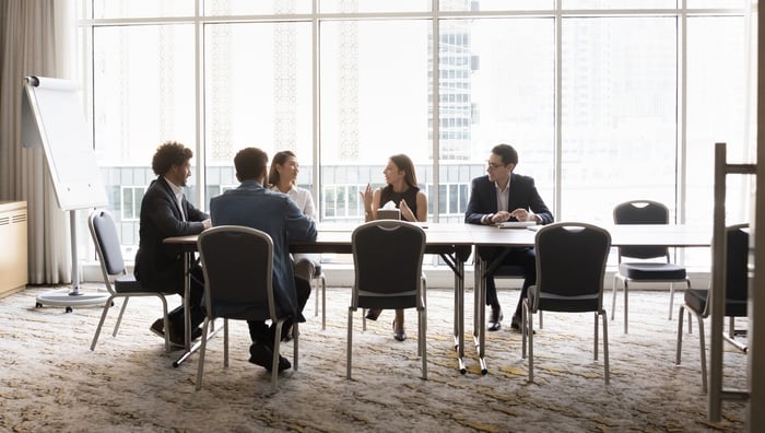 People talking at a conference room table.